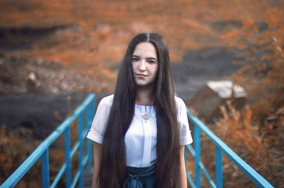 Young woman with long hair looking at the camera